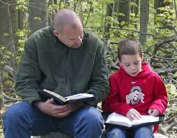 father and son reading Bible