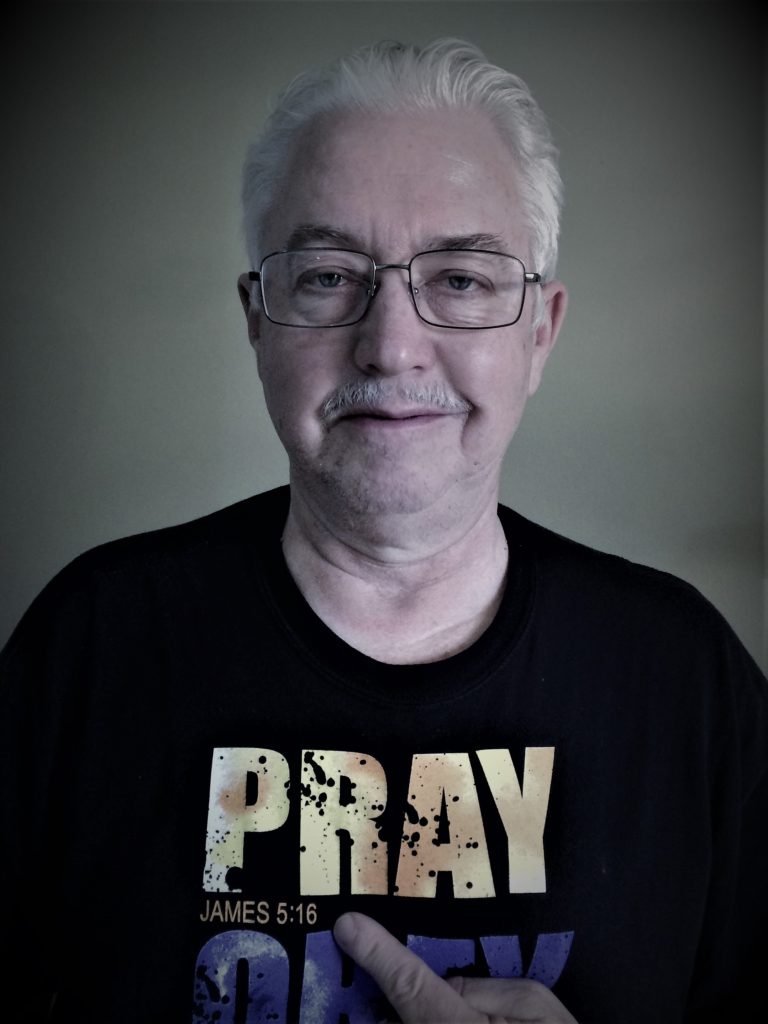 photo of man wearing t-shirt "PRAY" JAMES 5-16