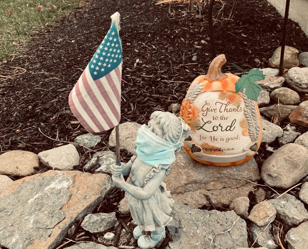 garden statue girl with flag and pumpkin "Give Thanks to the Lord"