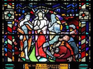 Stained glass window of Jesus with James, John and Peter at the transfiguration
