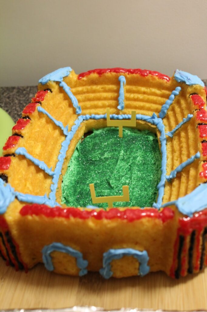 Christmas Bowl Game - football stadium cake with contemporary signs of sponsorship