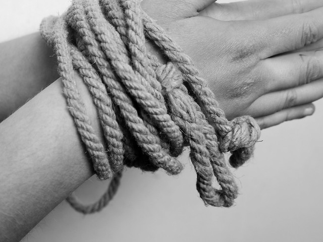 hands bound by rope (or rope belt of a tunic